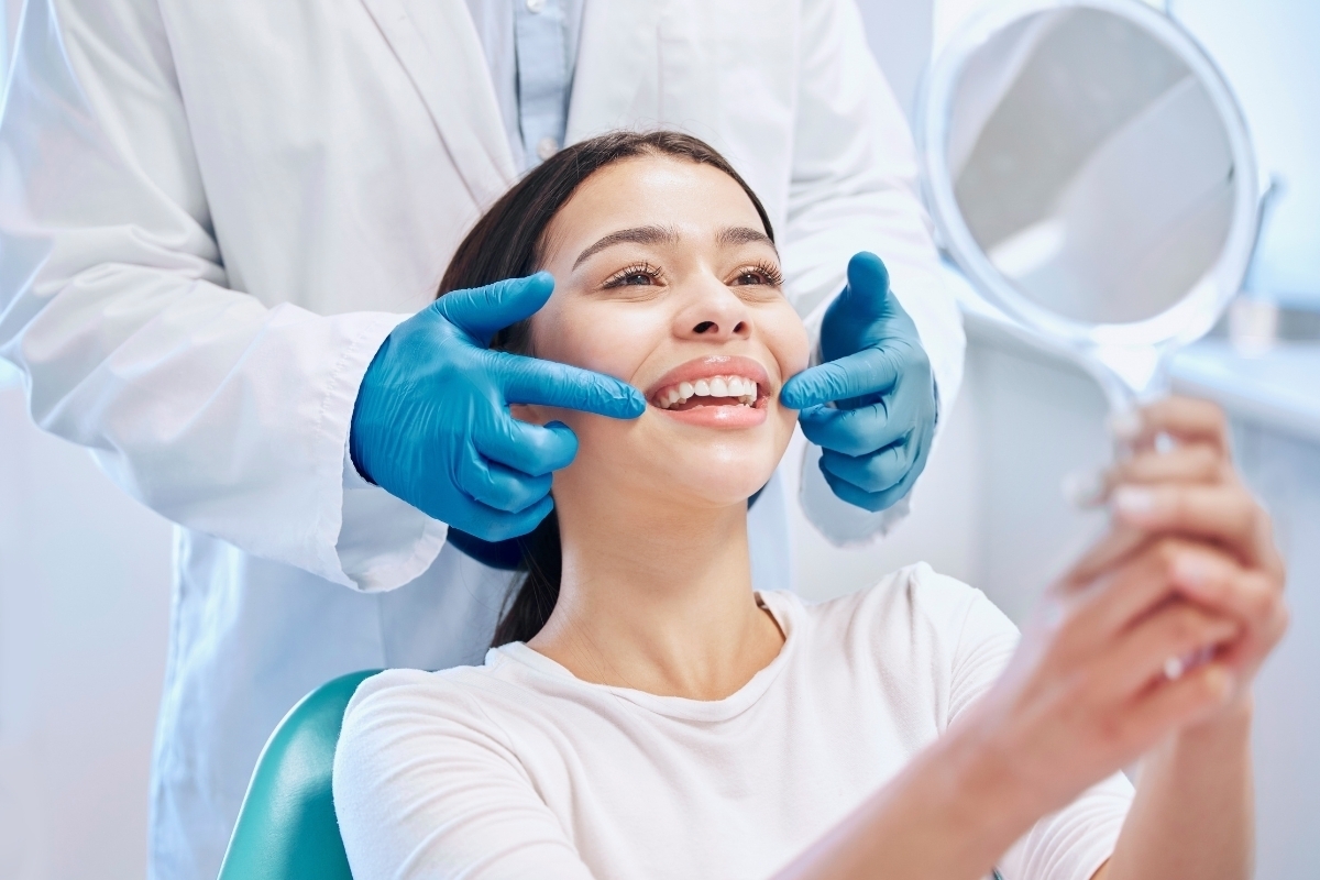 Smiling patient viewing teeth whitening results with dentist in Scottsdale dental office.