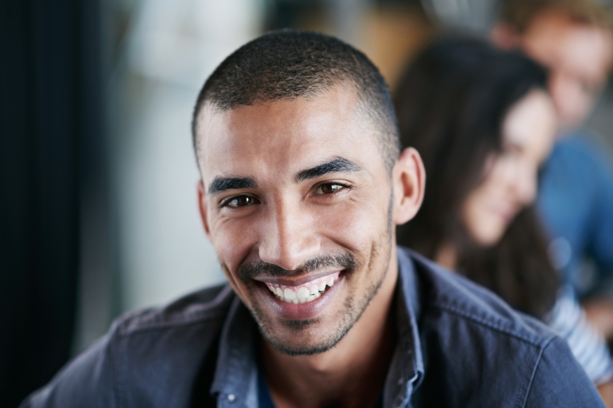 Man with healthy smile demonstrating results of cosmetic dental treatment like veneers or crowns.